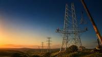 Transmission towers under construction at sunset